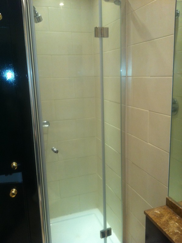 Frameless glass shower enclosure with chrome fittings in Thornton Heath